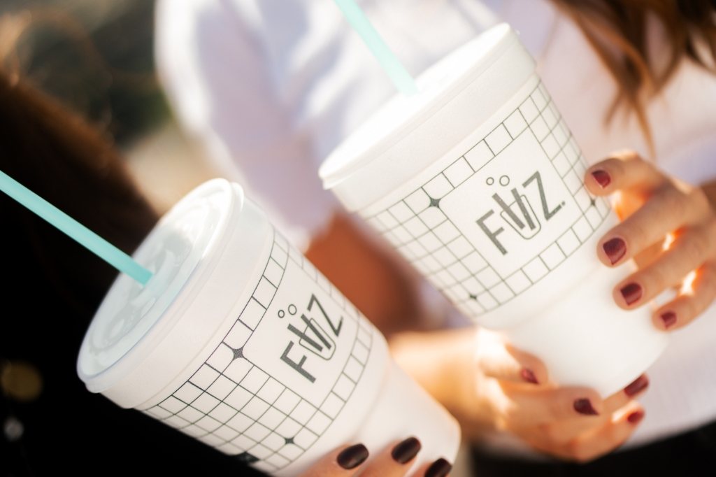 Two friends clinking FiiZ foam cups